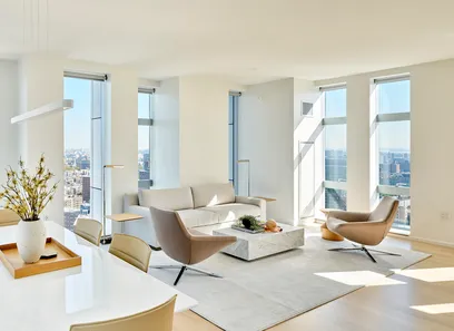 A modern conference room with two long white tables, red chairs, and tall windows on either side.