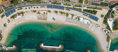An aerial view of a beach with tennis courts and umbrellas