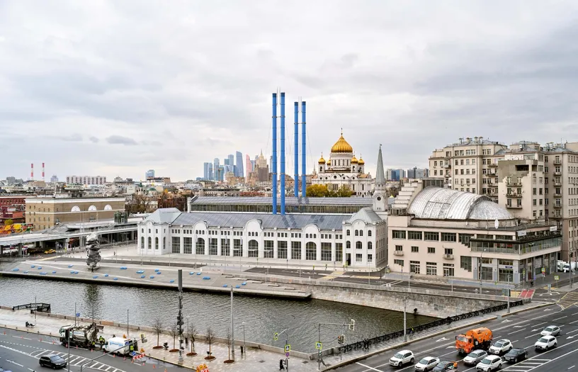 An aerial view of a city with a large building and a river in the foreground
