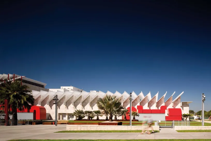 A large white and red building with a blue sky in the background
