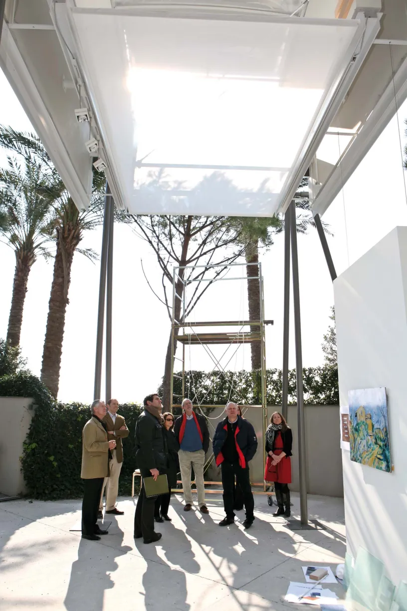 a group of people standing in front of a painting that says ' a ' on it