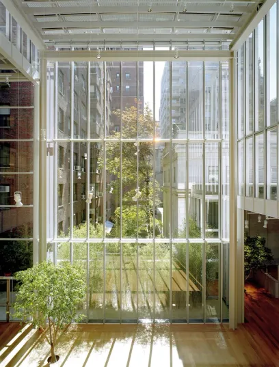 The inside of a building with lots of windows and trees