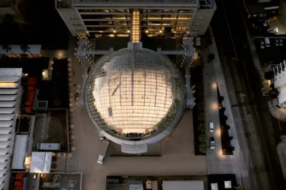 A group of people are standing in a large glass building