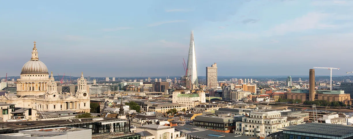 An aerial view of the city of london with a dome in the background
