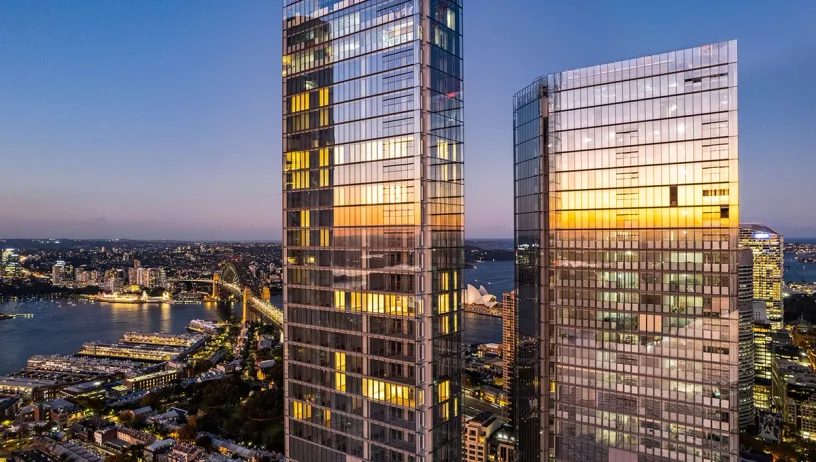 an aerial view of two tall buildings in a city at night