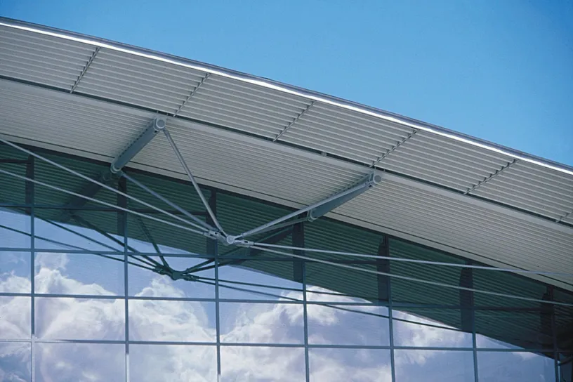 The roof of a building with a lot of windows and a blue sky in the background