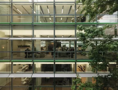 A large office building with lots of windows and trees in front of it