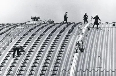 A group of construction workers are working on the roof of a building