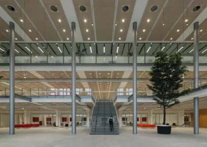 A man is walking down a set of stairs in a large building