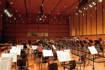 A large orchestra is sitting in an empty auditorium