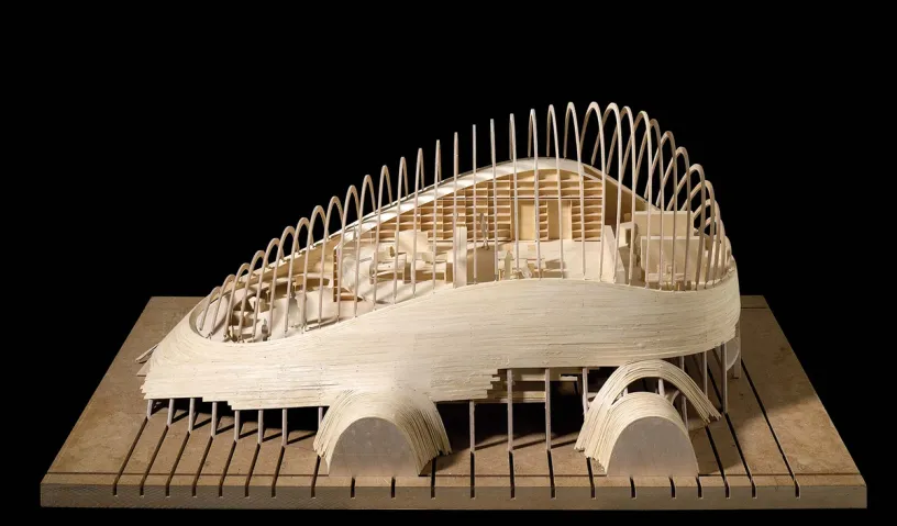 A model of a building made out of wood on a black background