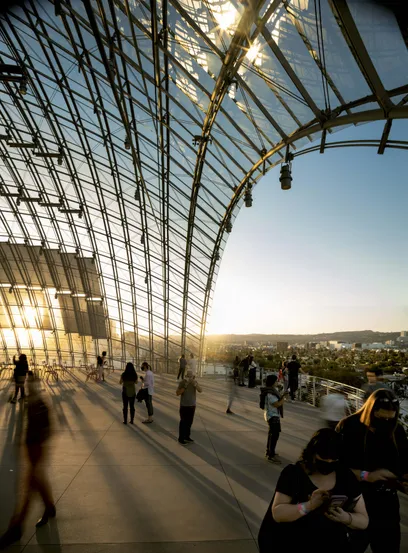 A group of people are standing in a large glass building