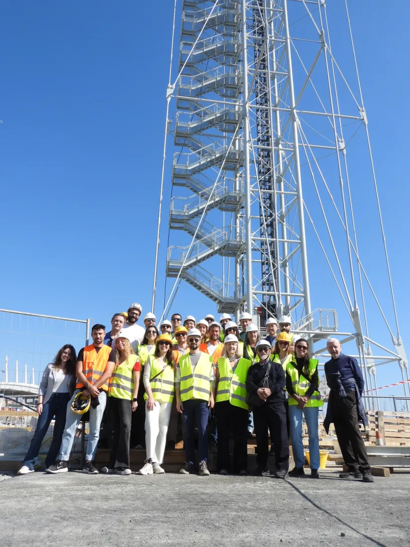 a group of people wearing hard hats and safety vests pose for a picture