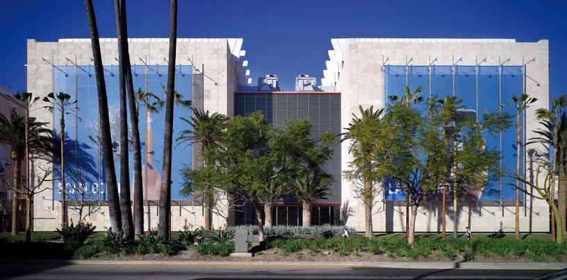 A large building with a lot of windows and palm trees in front of it
