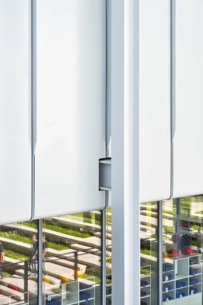 A building with a lot of windows and a reflection of people in the windows