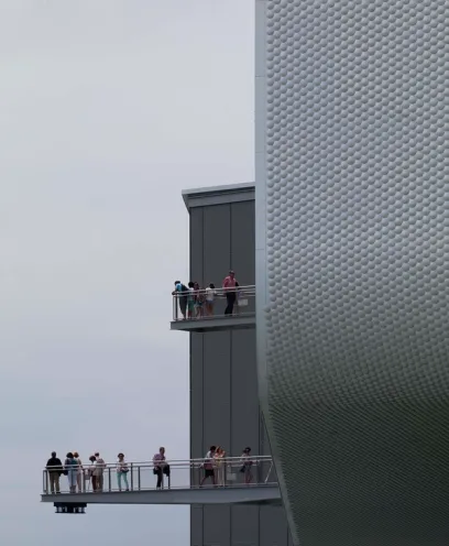 A group of people standing on a bridge between two buildings