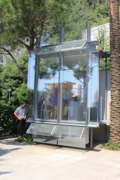 A man stands in front of a glass building