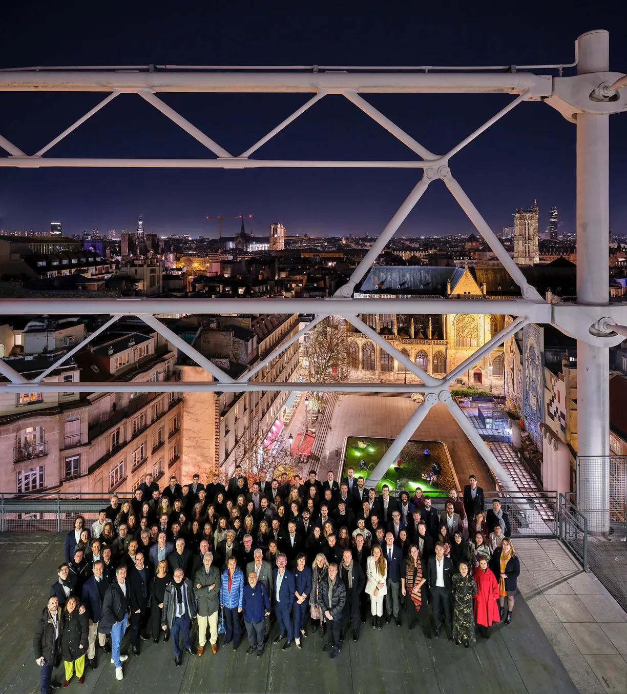 A large building that looks like a boat is lit up at night