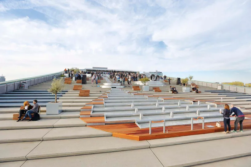 A group of people are sitting on the steps of a building