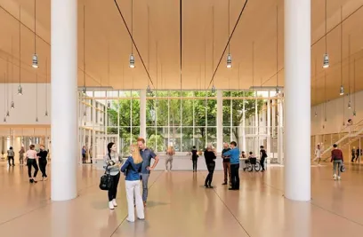 A group of people are standing in a large room with a lot of windows