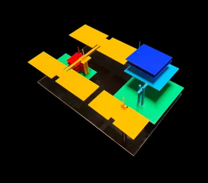 Vibrant architectural model with geometric yellow, red, green, and blue blocks on a dark base.