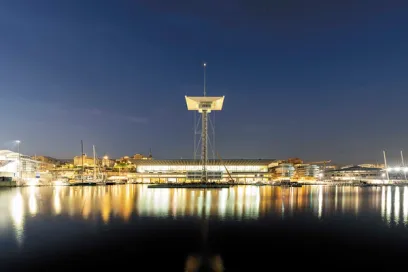 A large building in the middle of a harbor at night