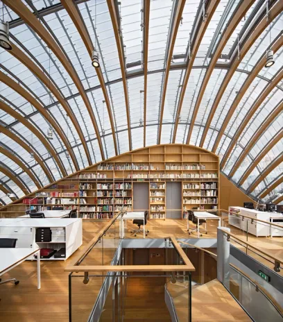 A large library with a glass ceiling and wooden shelves