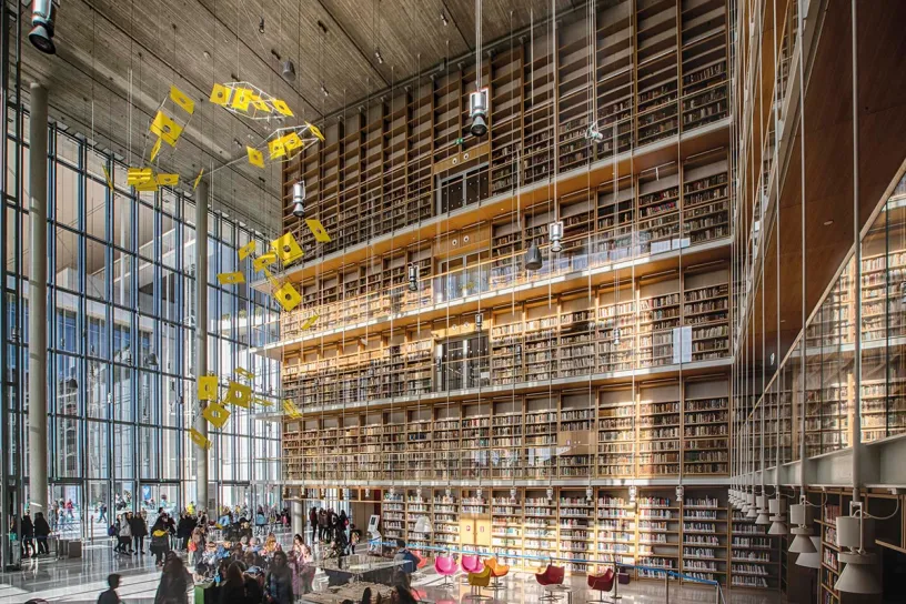 A large library filled with lots of books and people
