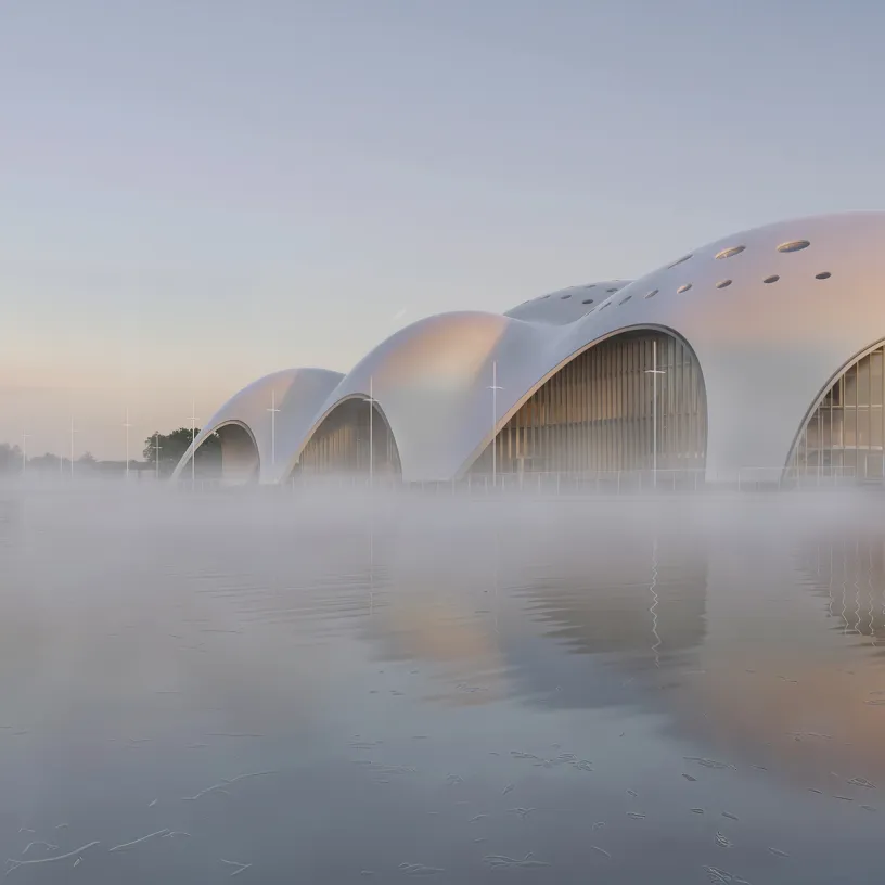 a large white building is surrounded by fog over a body of water