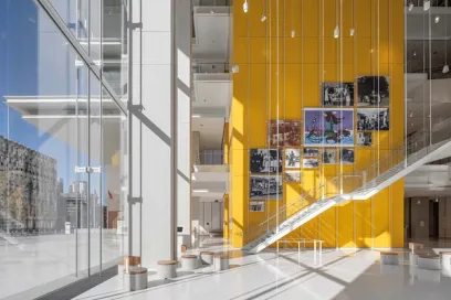 A large lobby with a yellow wall and stairs in a building