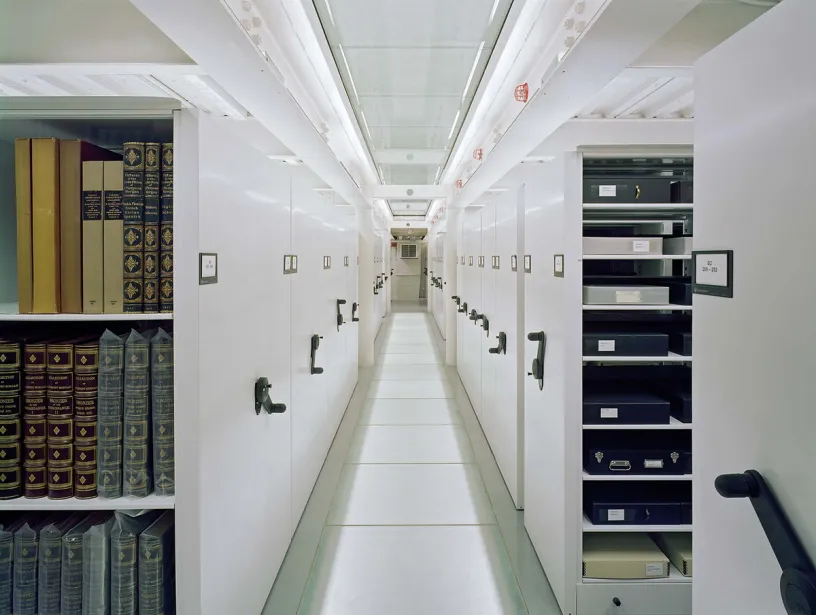 A long hallway filled with shelves filled with books and boxes