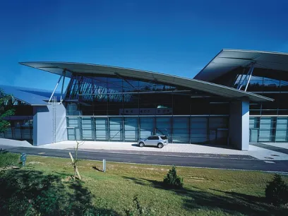 A car is parked in front of a large building