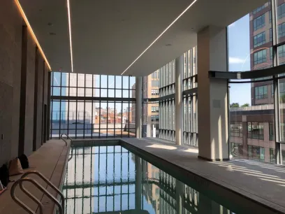 a large indoor swimming pool in a building with lots of windows .