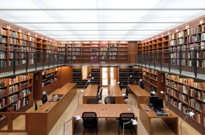 A large library filled with lots of books and tables and chairs