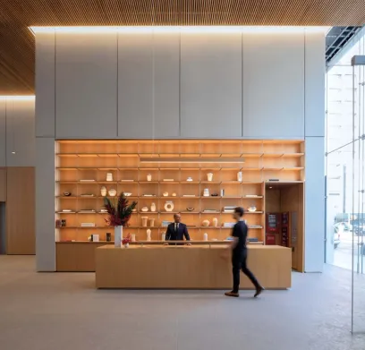a man is walking past a reception desk in a lobby .