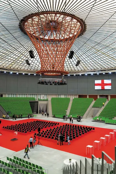 A large stadium with green seats and a red carpet