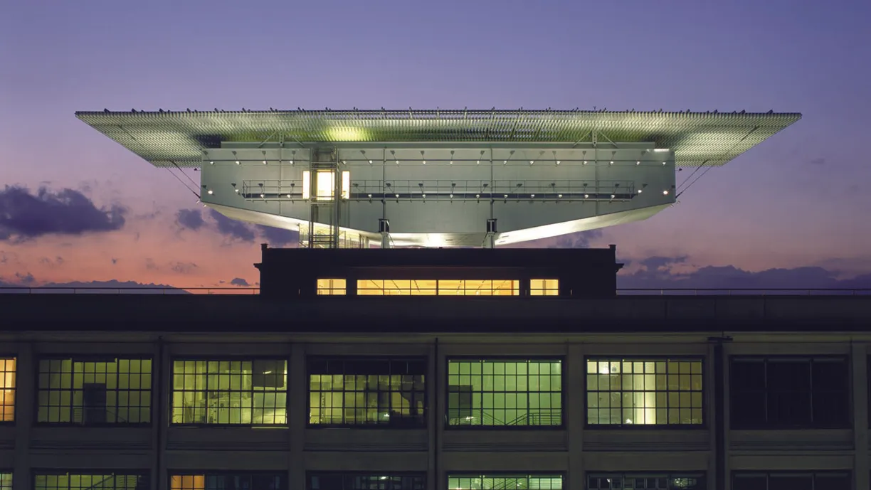 a large building with a large roof and a lot of windows at night .