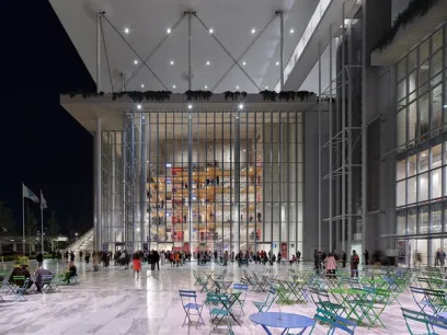 A large building with a lot of windows and tables and chairs in front of it