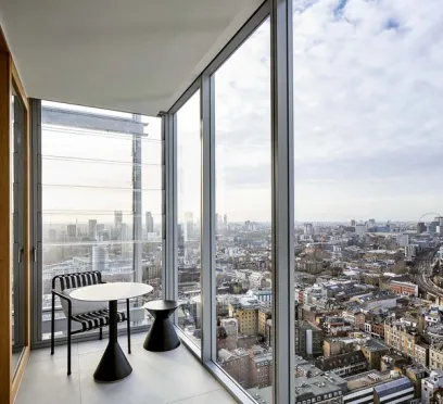 a balcony with a table and chairs and a view of the city .
