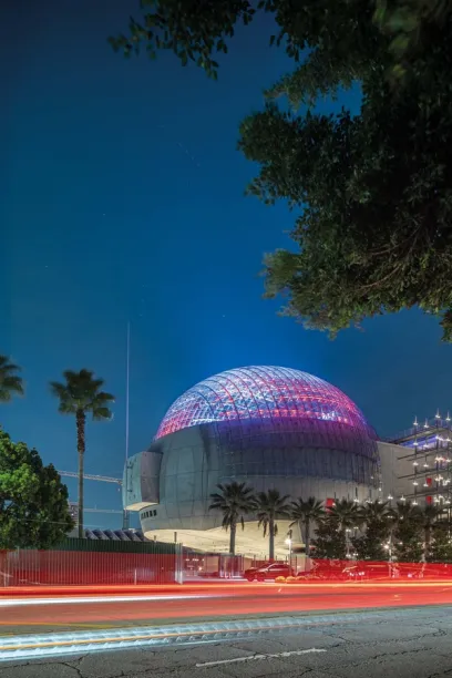 A large dome with a purple roof is lit up at night