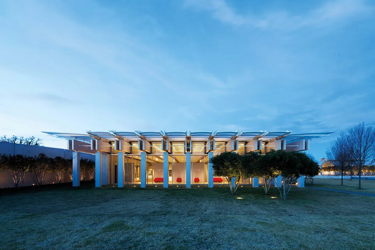 A large building with a lot of windows and trees in front of it