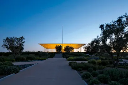 A large building with a flag pole in the background is lit up at night
