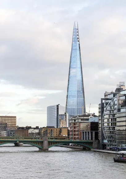 A bridge over a body of water with a tall building in the background