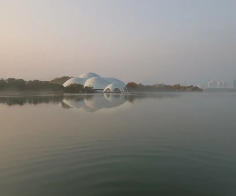 a large white dome is reflected in the water of a lake .