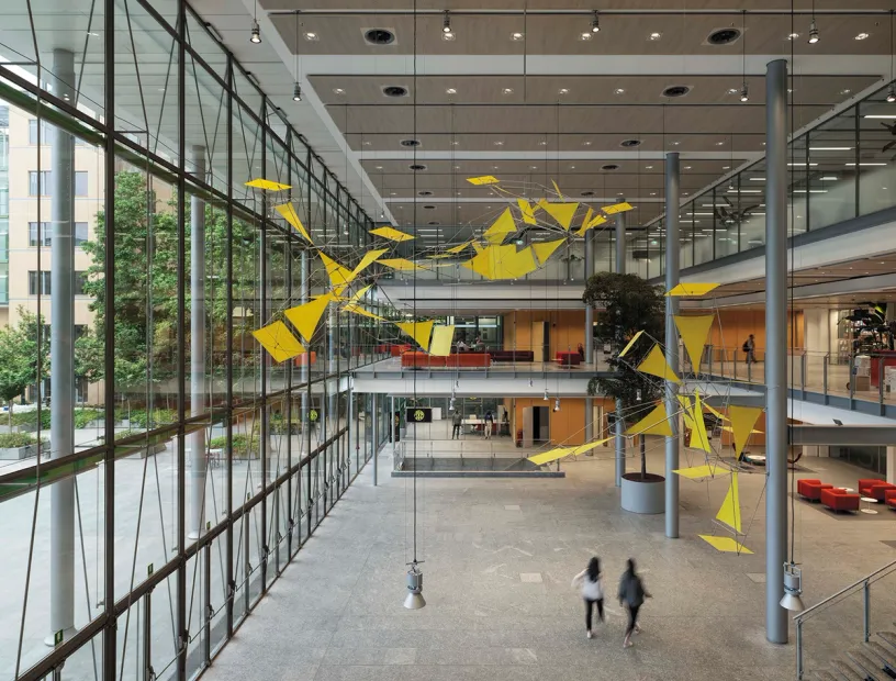 A large building with a lot of windows and a sculpture hanging from the ceiling