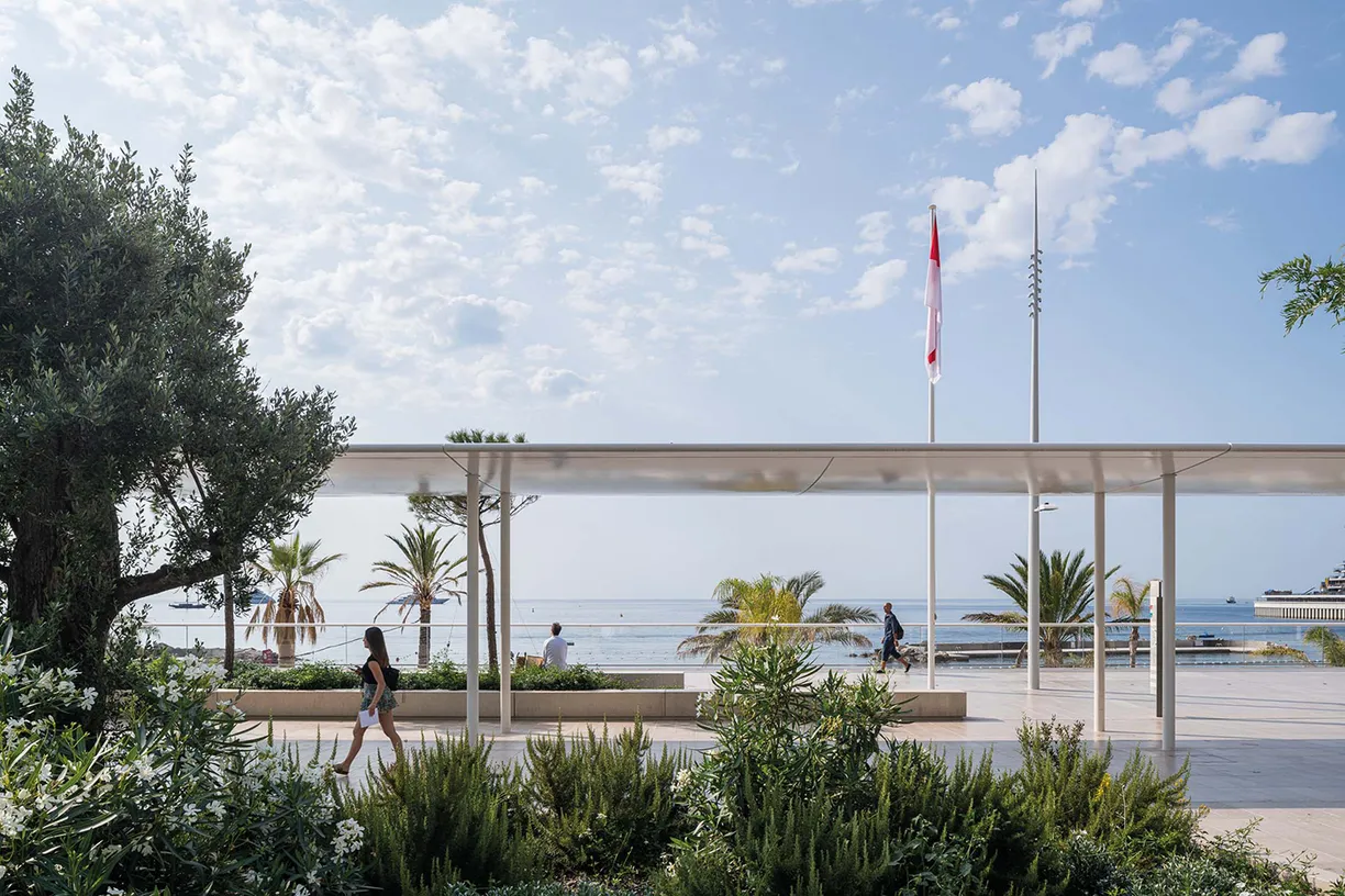 A woman is walking under a canopy overlooking the ocean