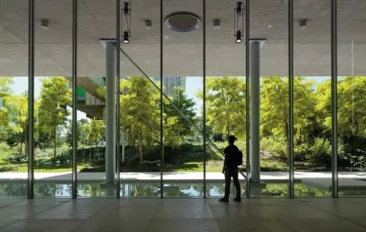 A man is standing in front of a large window in a building