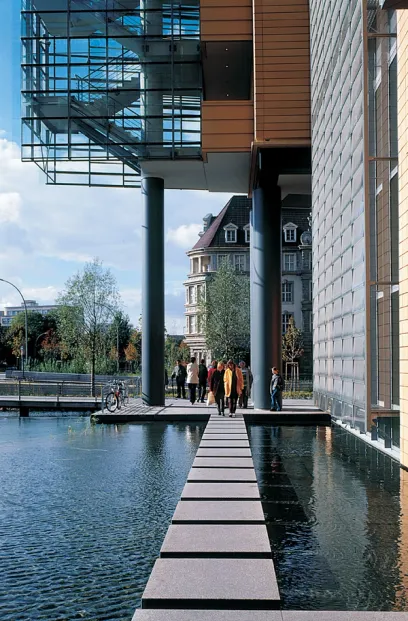 A group of people are walking across a bridge over a body of water