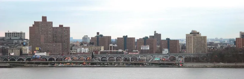 a man is walking down a city street next to a bus stop .