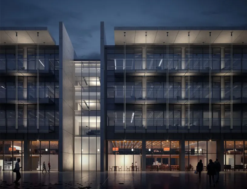 A group of people are walking in front of a large building at night